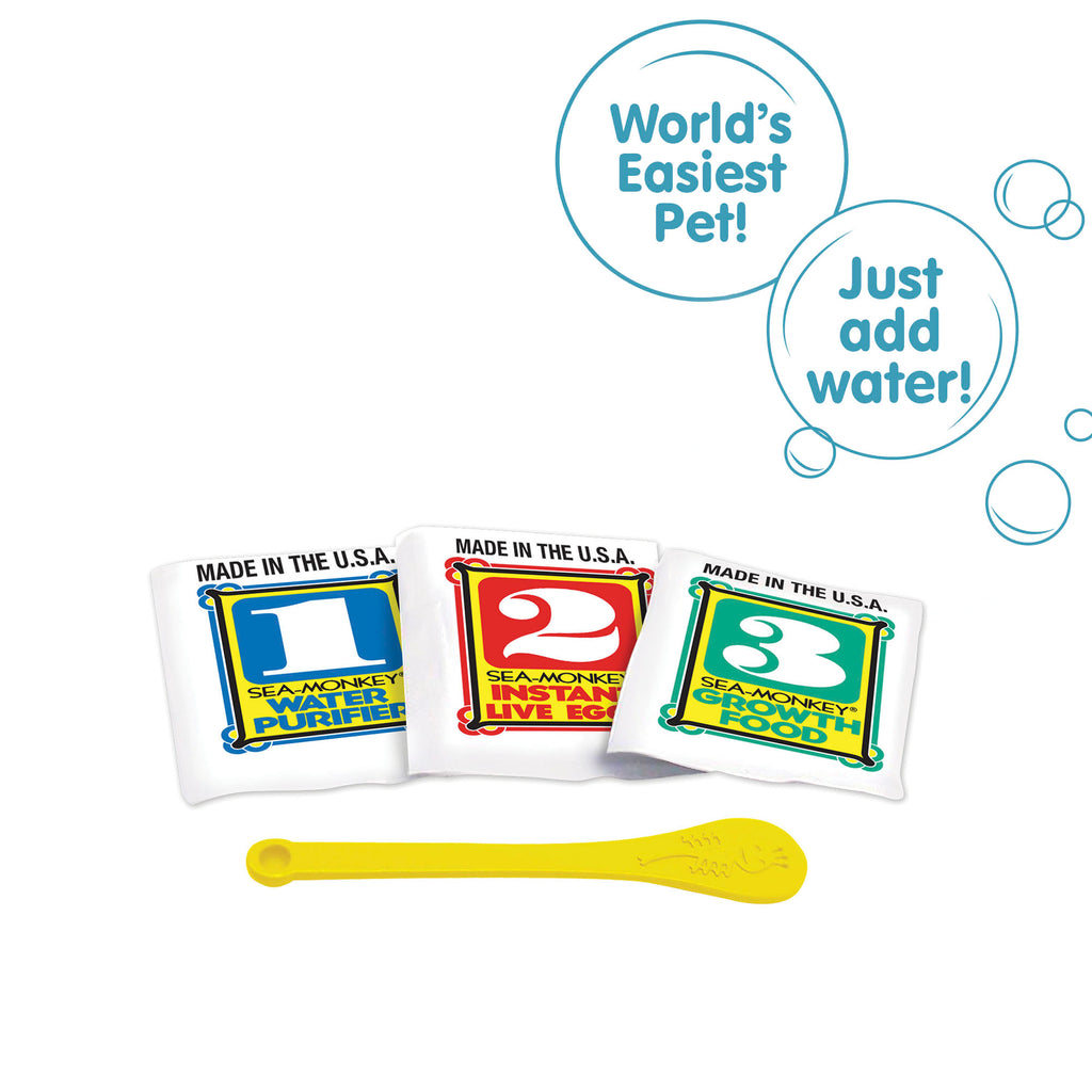 Three packets, numbered 1, 2, and 3 from left to right. There is a small yellow Sea-Monkeys spoon laying in front of the packets. There are two callouts in circles. One reads "World's Easiest Pet!" and the other reads "Just add water!"